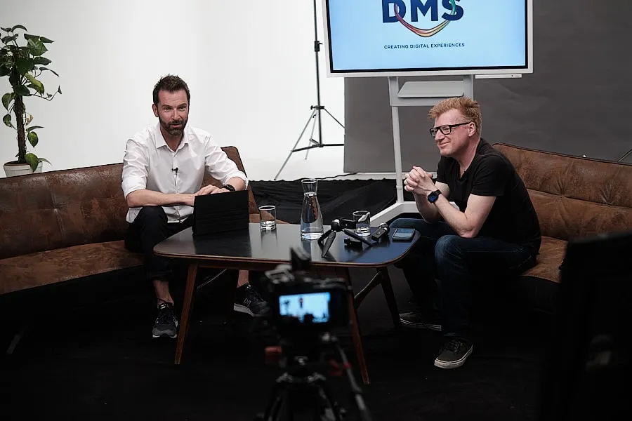 Livestream-Studio bei DMS: Wolfgang Lehner im Gespräch auf dem Sofa, im Vordergrund die Kamera