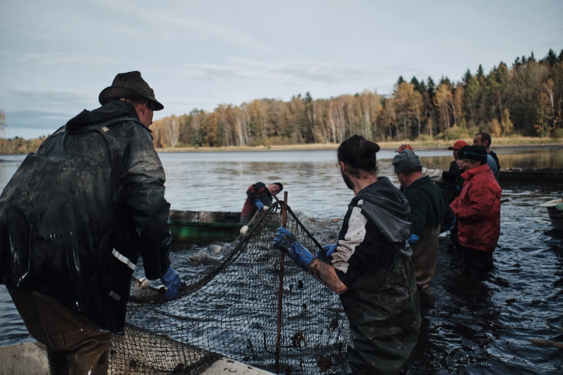 Die Mannschaft zieht gemeinsam das Zugnetz durch das flache Wasser Richtung Ufer.